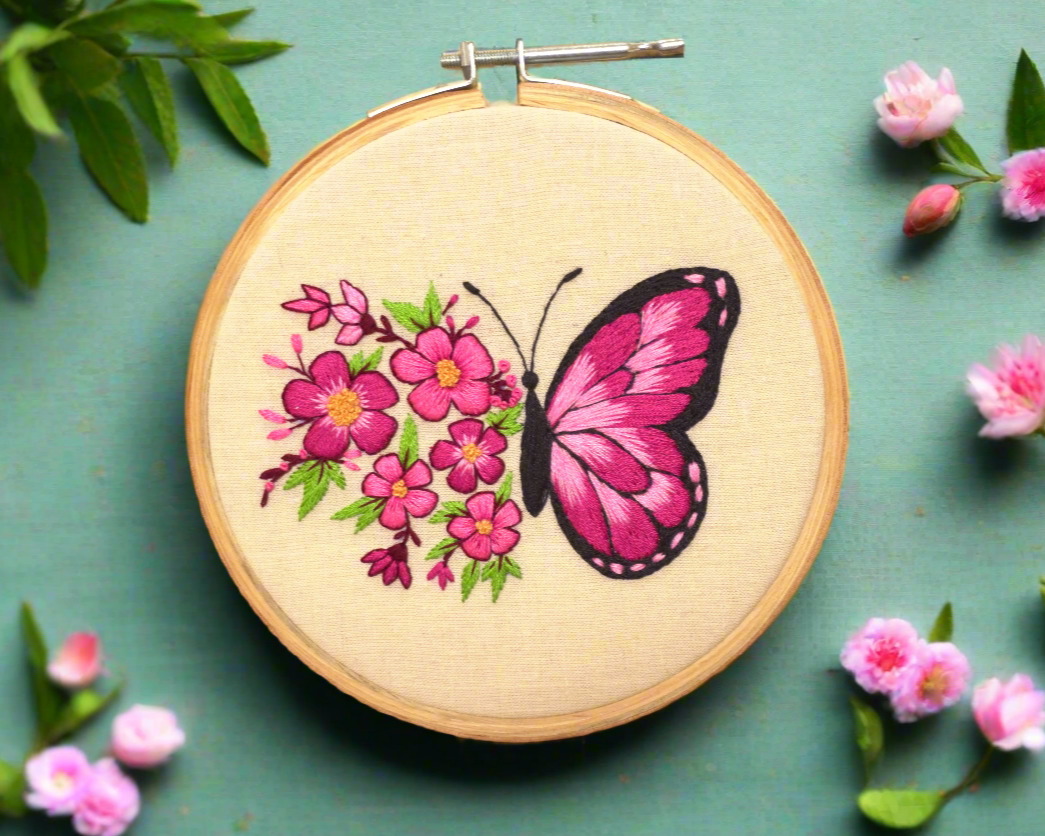 super creative butterfly embroidery floral design on cream fabric with different shades of pink flowers, green leaves and yellow pollen at the center of each flower.