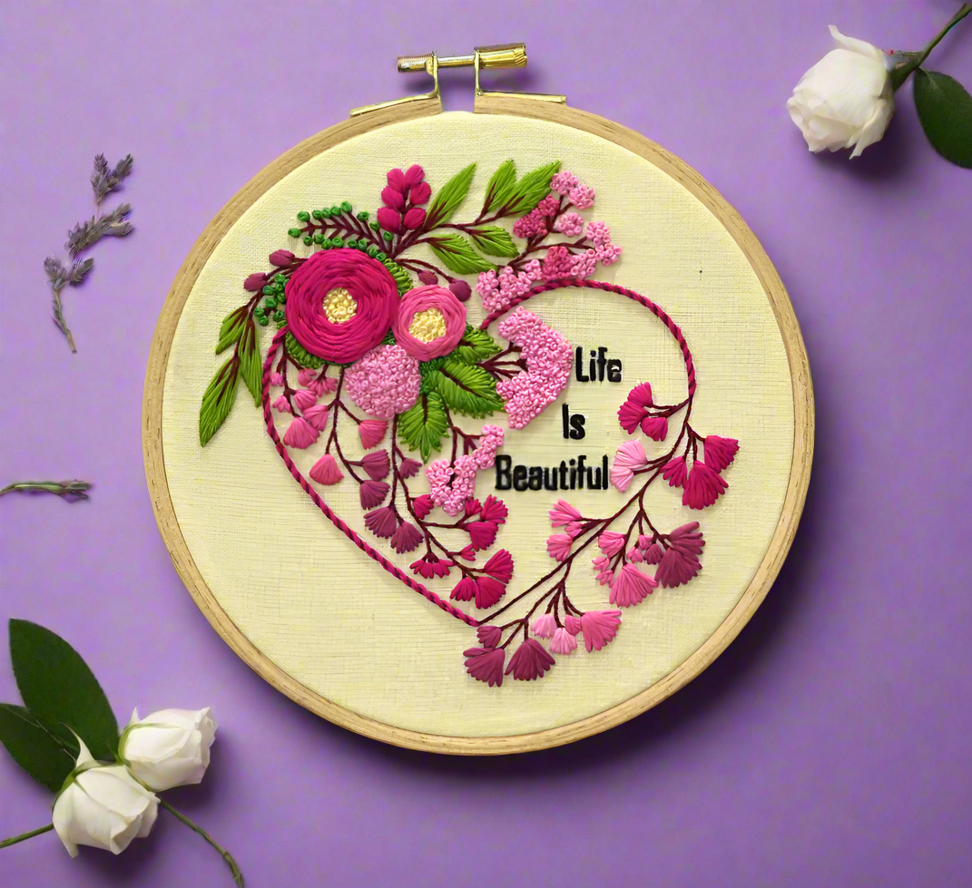 beautiful embroidery hoop with pink floral heart shape embroidery design, green leaves, pink buds and life is beautiful lettering, spiring flowers theme embroidery pattern