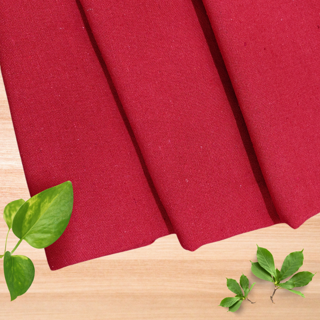 Casement for embroidery in red colour pleats placed on wooden surface with 3 leaf bunches inspired by nature
