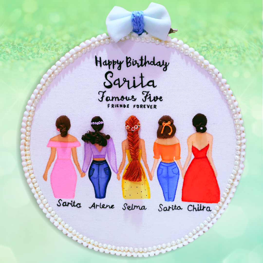 A personalized round embroidered hanging plaque with a white pearl-beaded border and a white bow at the top. The center reads 'Happy Birthday Sarita Famous Five FRIENDS FOREVER' above illustrated women in pink, blue, yellow, orange, and red dresses, with names written below each figure.