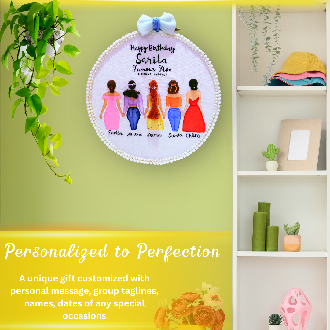 A round friendship celebration birthday hoop decorated with peals, pom pom and blue bow with 5 illustrated girls holding hands in colorful dresses and different hairstyles