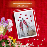 A product presentation of a custom photo-embroidered rectangular frame or print sample, shown with dimension arrows indicating 13 cm by 18 cm. The sample features a black and white photo of a couple wearing red garlands, surrounded by red embroidered hearts.