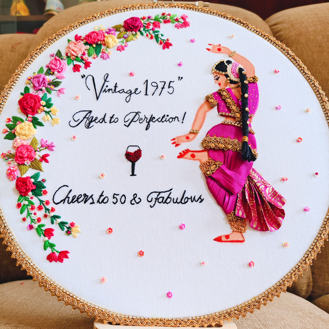 Hand embroidered traditional indian woman dancing pose in pink with golden border and stone chain accessories and floral and pearl embroidery details, cutom text on white fabric
